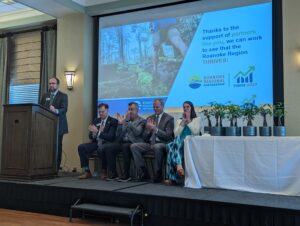 John Hull, executive director of Roanoke Regional Partnership, standing at podium with board members seated behind him