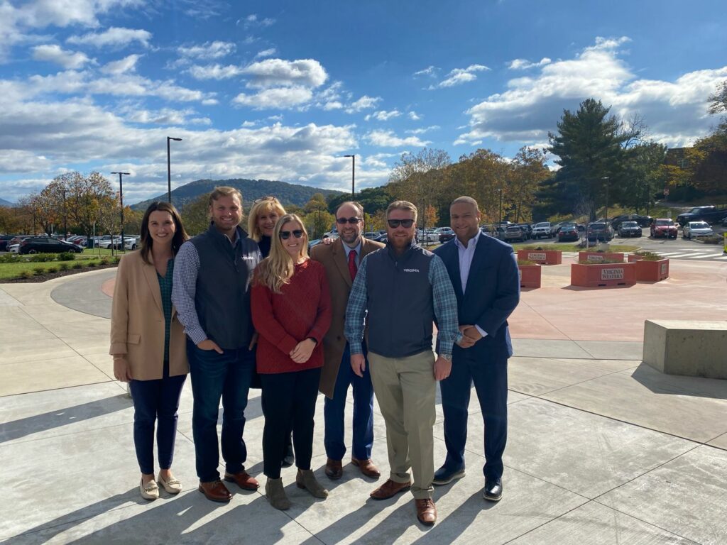 Group of people smiling for the camera outside on a sunny day