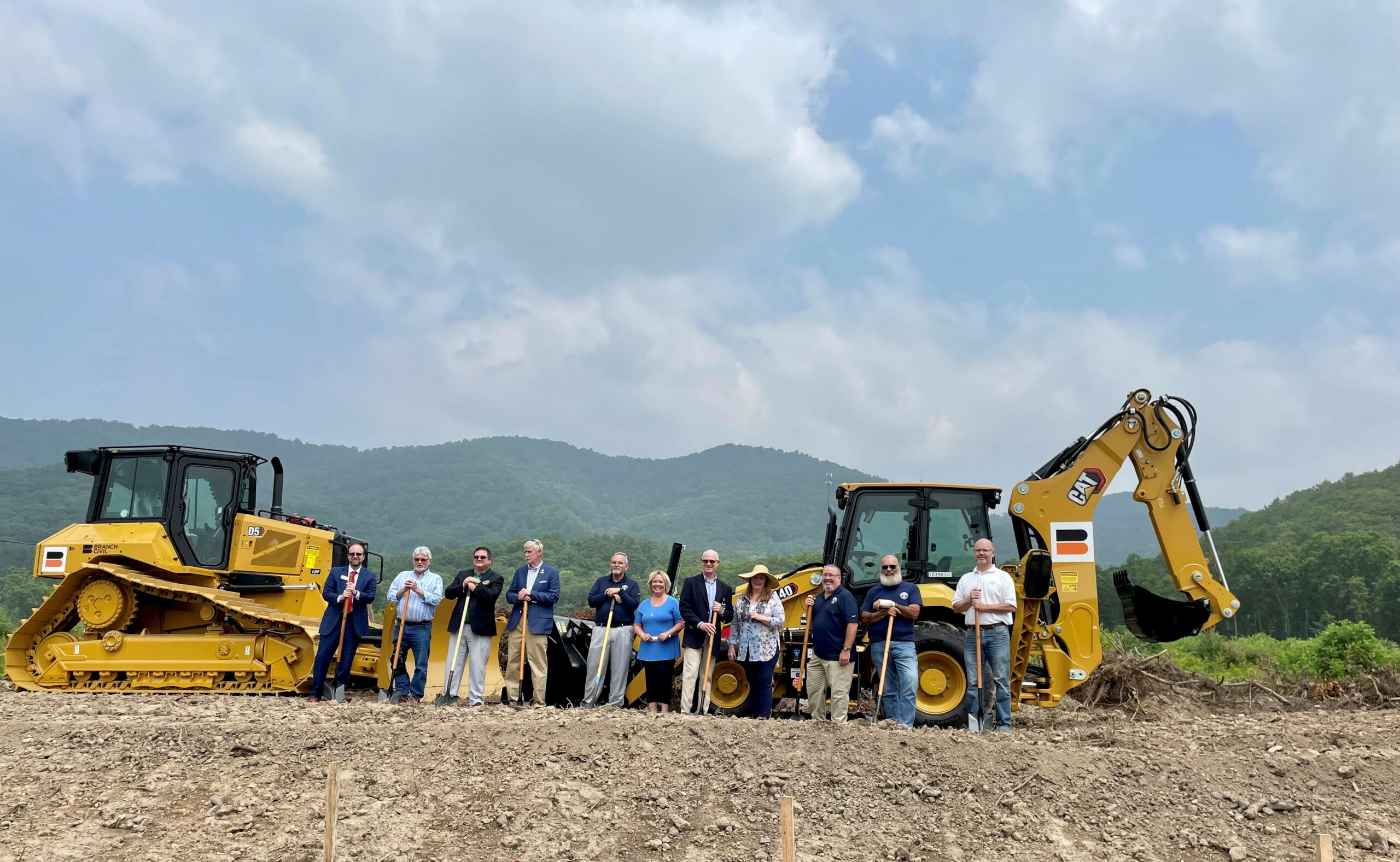 several people with shovels at a groundbreaking event for a new building