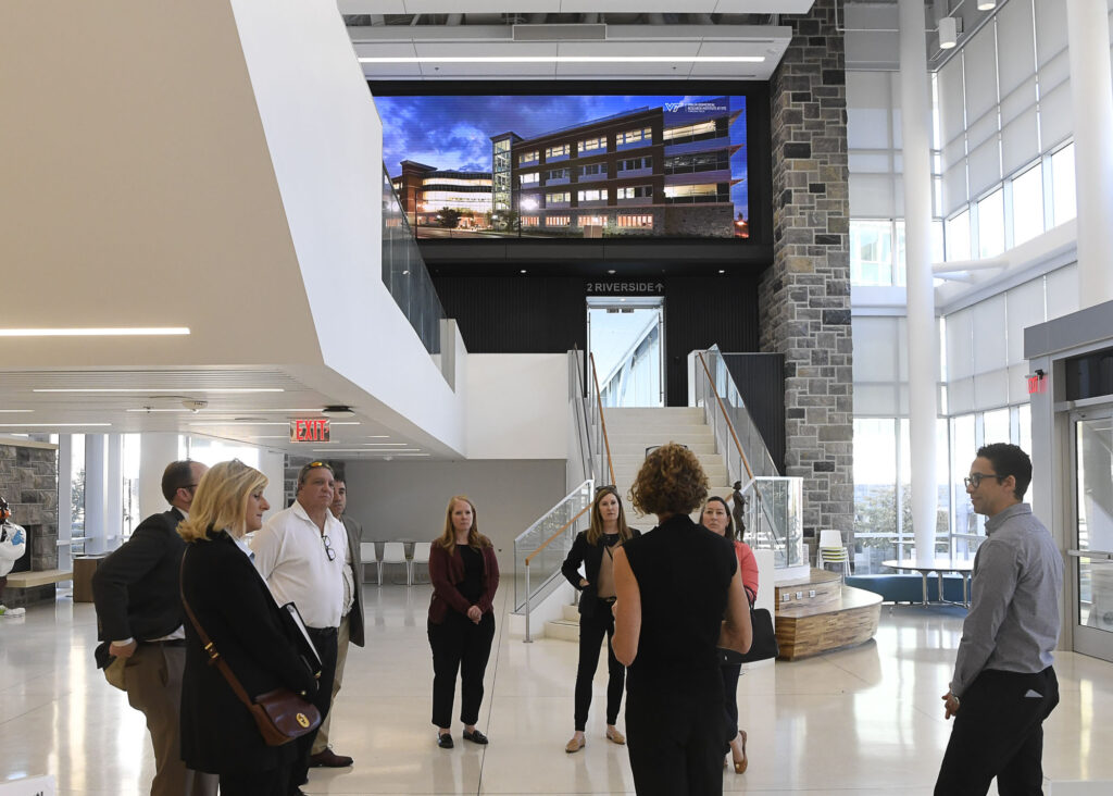 A group of people gathers at the atrium of the Fralin Biomedical Research Institute for a presentation.