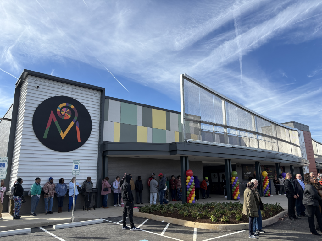 Exterior of the new Market on Melrose in Northwest Roanoke, VA. The building is modern and there are balloon pillars out front  for the grand opening celebration