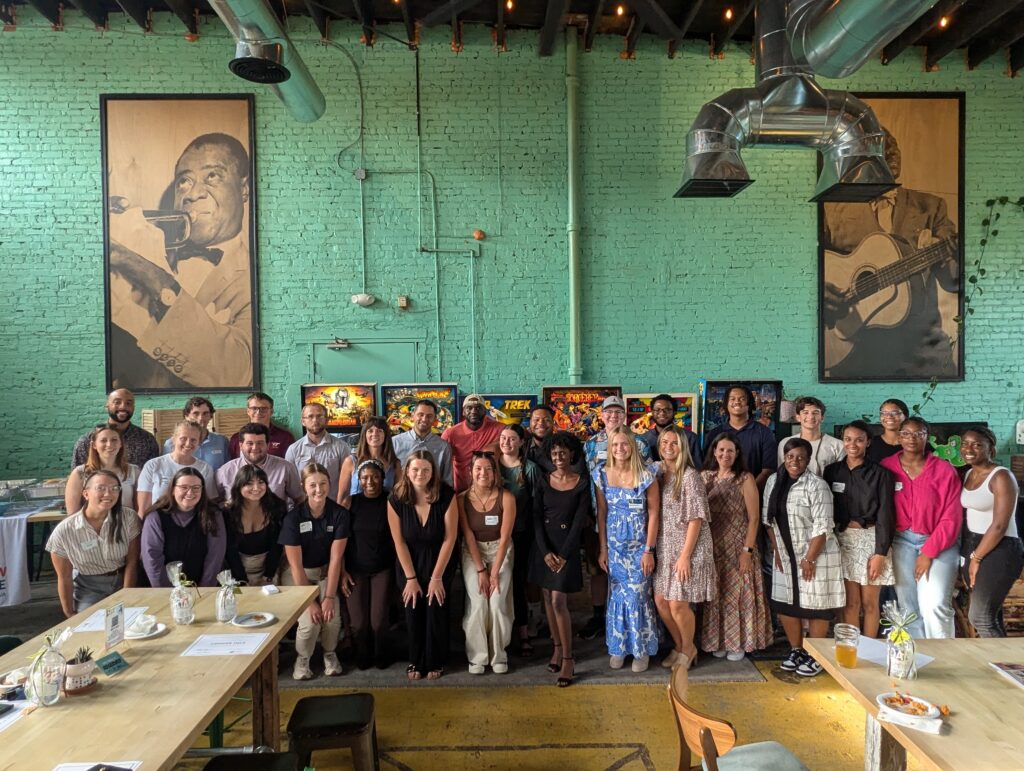 A group of over 50 young professionals are gathered in a brewery to celebrate the completion of the Onboard ROA program put on by Get2KnowNoke.